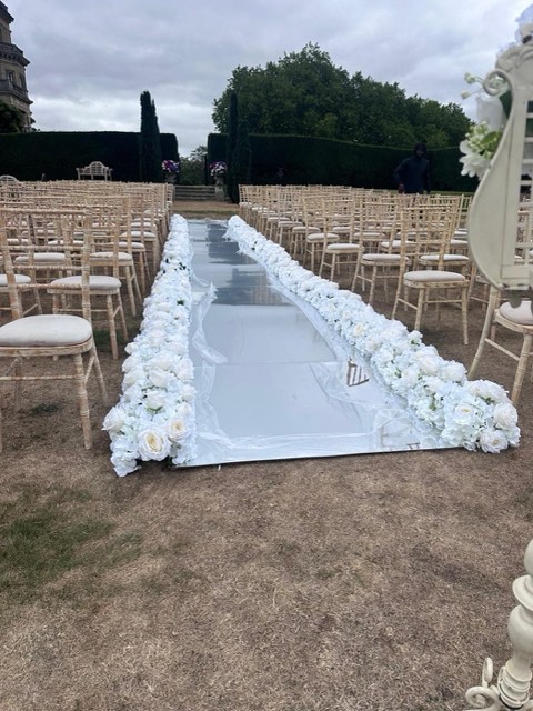 Outdoor aisle lined with white flowers