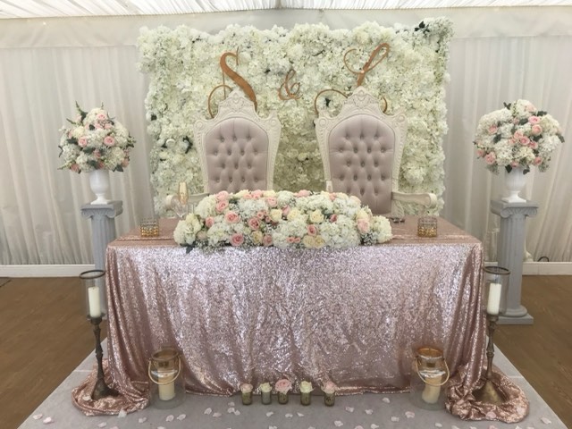 Sweetheart table with flower wall and sequin cloth